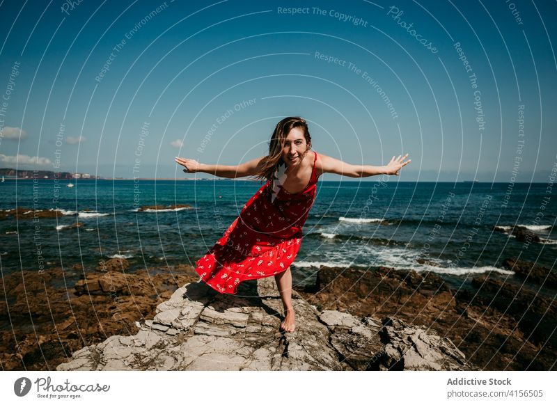 Graceful woman in dress on rocky hill grace red balance tender delight move slim female barefoot rough blue sky cloudless heaven nature serene sensual freedom