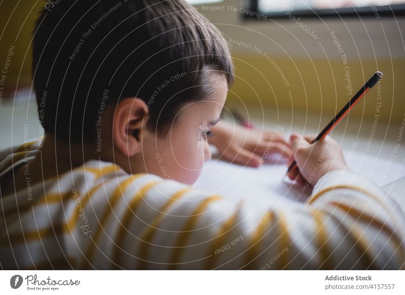 Adorable child drawing on paper picture pencil cute playful creative kid weekend home having fun entertain childhood adorable sweet charming innocent cheerful