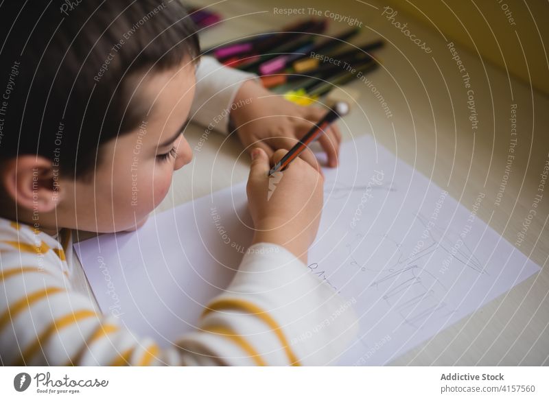 Adorable child drawing on paper picture pencil cute playful creative kid weekend home having fun entertain childhood adorable sweet charming innocent cheerful