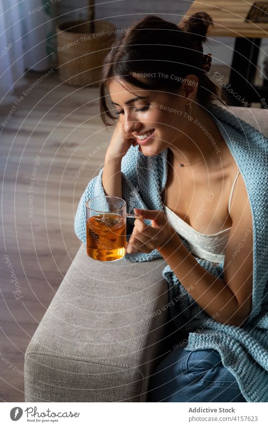 Thoughtful woman drinking tea on sofa pensive cozy home thoughtful relax chill young female warm couch comfort beverage rest calm tranquil lifestyle mug serene