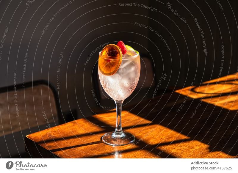 Glass of cold cocktail on table in bar glass drink alcohol ice orange fruit beverage goblet crystal refreshment cool pub citrus slush liquid restaurant tasty