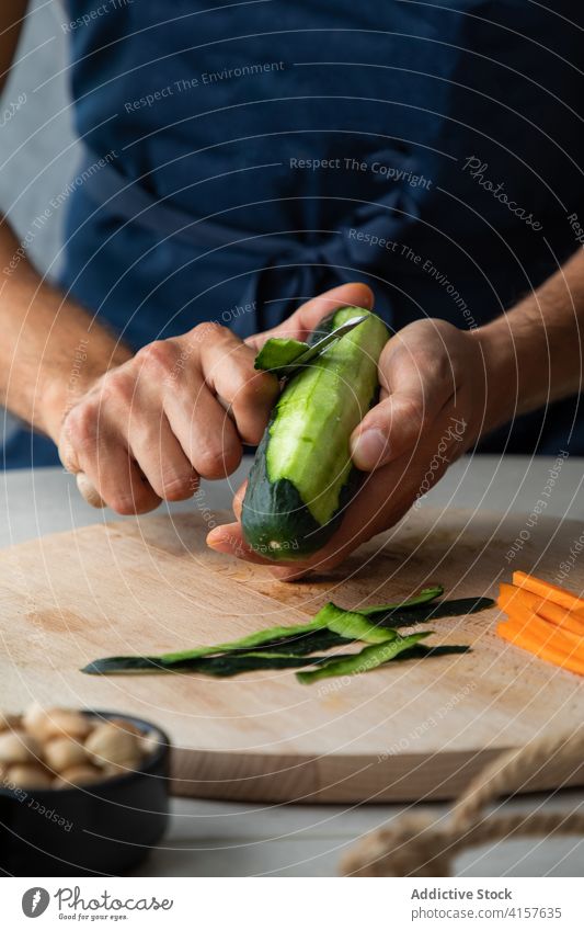 Cook peeling zucchini for vegetarian dish cook vegetable food prepare fresh kitchen culinary ingredient healthy knife cuisine meal organic diet hand chef green