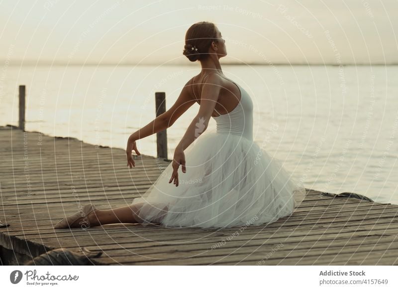 Graceful ballerina performing dance on pier grace sea flexible classic ballet elegant sensual pose woman dancer slim young female stretch balance beautiful