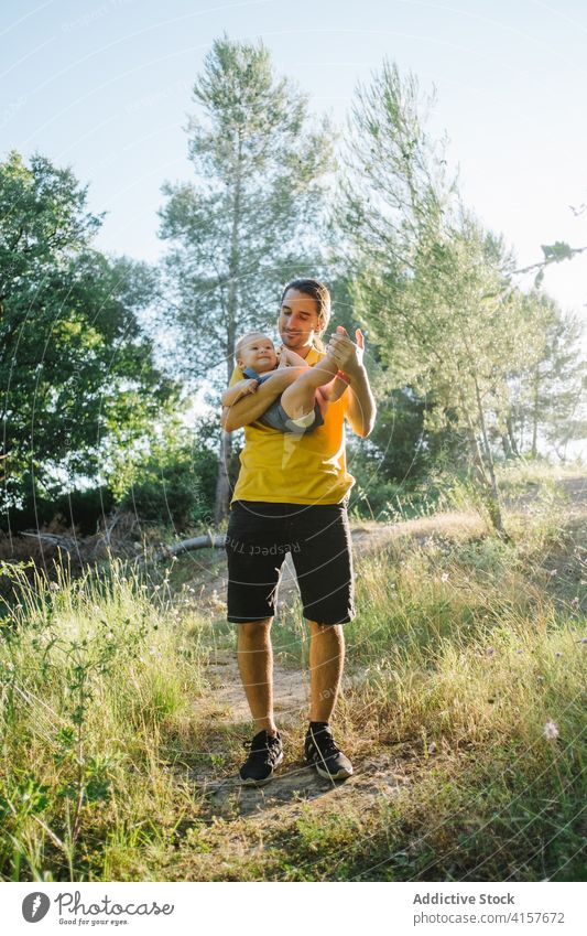 Young man playing with toddler in park father child together summer having fun adorable idyllic innocent weekend kid little enjoy relax childhood happy cheerful