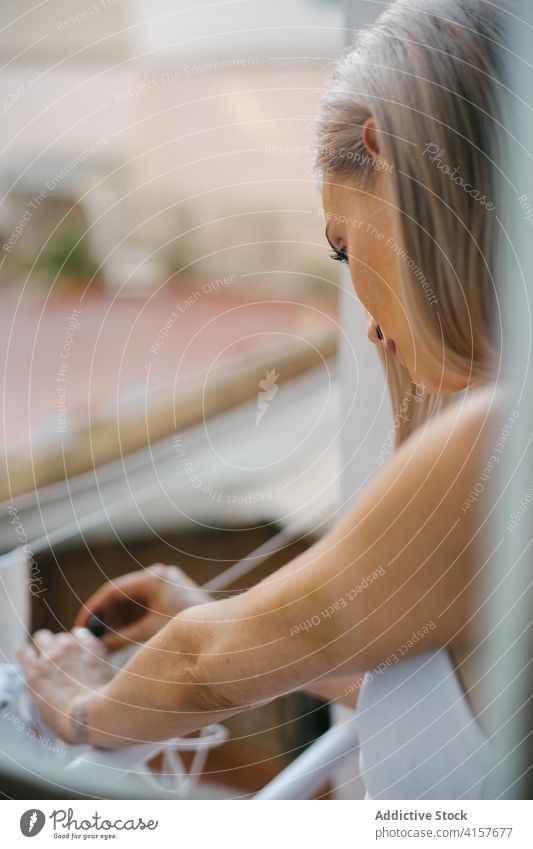 Calm woman hanging clothes outside window household clothespin dry clothesline housework laundry female apartment domestic outfit home wet weekend harmony