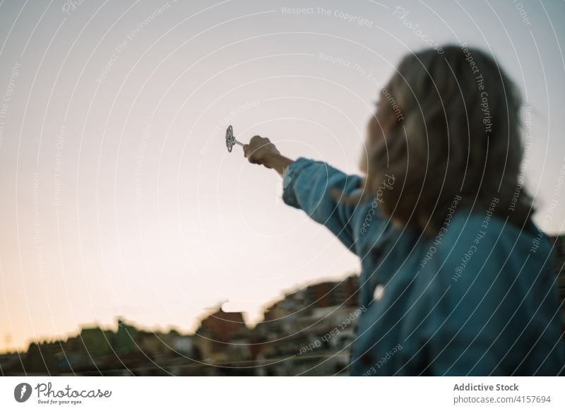 Woman with magic wand on rooftop dreamy woman spell miracle enchantress building conjure female sit fantasy imagination inspiration romantic mystery mystic