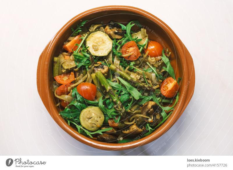 Seasonal vegan mediterranean pasta pot with asparagus, zucchine, tomato, champigon and arugula food zucchini champignon terracotta vegetarian mushroom rocket