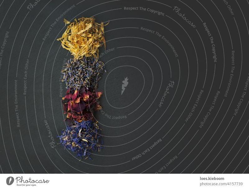 Top view of floral herbs - dried marigold, lavender, rose and cornflower petals as ingredients for cooking natural medical abstract food nature leaf medicine