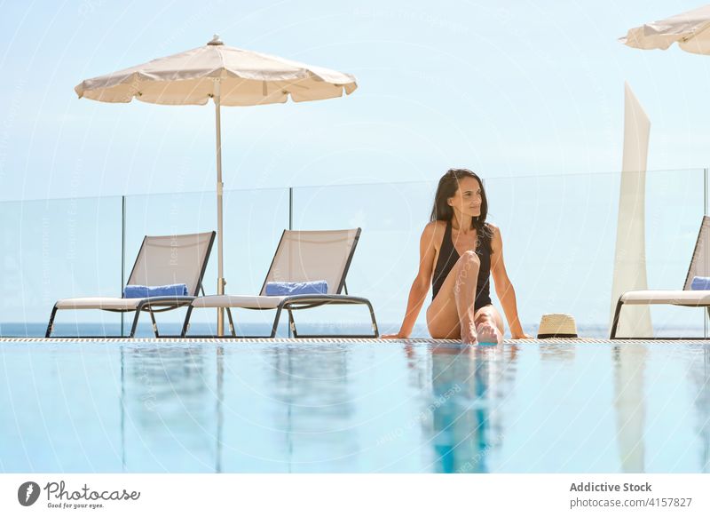 Relaxed female tourist resting near pool in hotel woman poolside suntan resort summer chill enjoy relax leisure harmony travel wellness tourism recreation