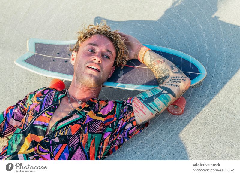 Hipster skater man resting in skatepark skateboard ramp hipster style activity trendy young male lifestyle modern millennial funky deck recreation individuality