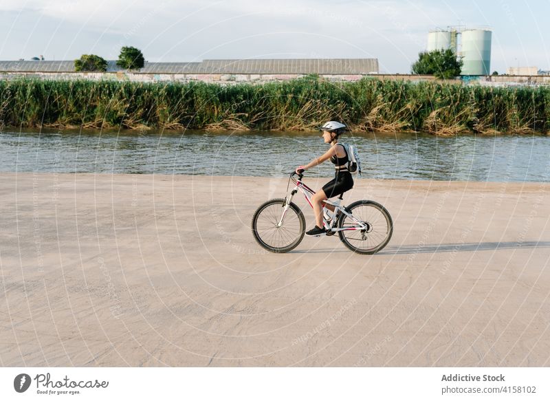 Happy woman riding bike on dirt path bicycle ride cyclist happy activity sporty nature countryside cheerful exercise young female helmet lifestyle way enjoy