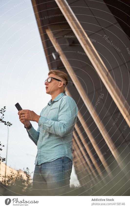 Busy male freelancer using smartphone on street businessman building city style entrepreneur browsing handsome mobile urban device professional contemporary