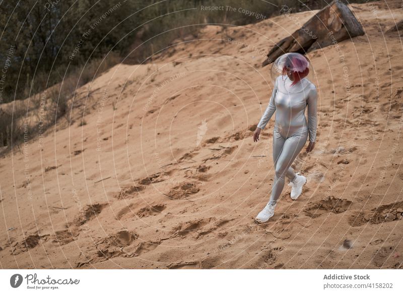 Smiling futuristic woman in sliver suit space astronaut positive young rock stone cosmonaut costume concept female silver helmet smile confident happy cheerful