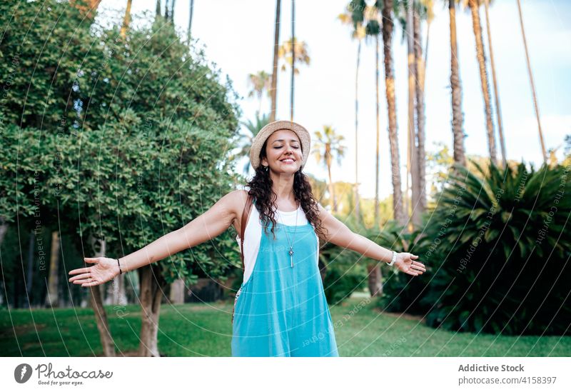 Carefree woman standing in tropical park carefree travel wanderlust enjoy vacation dreamy freedom female summer traveler relax holiday exotic rest journey