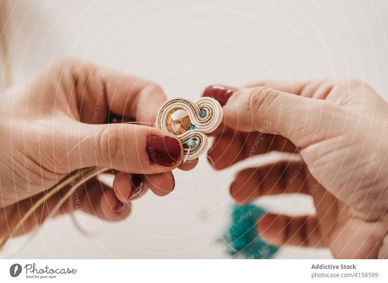 Crop woman creating soutache decorations in workshop technique bijouterie creative create maker handmade needle female artisan craft professional studio