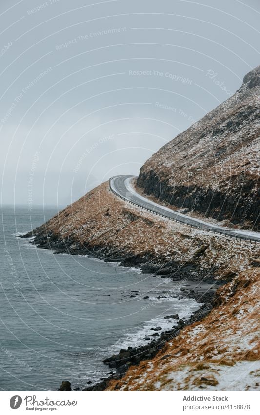 Asphalt roadway in highland area on Faroe Islands mountain river winter snow asphalt direction nature landscape faroe islands scenic water frost range cold