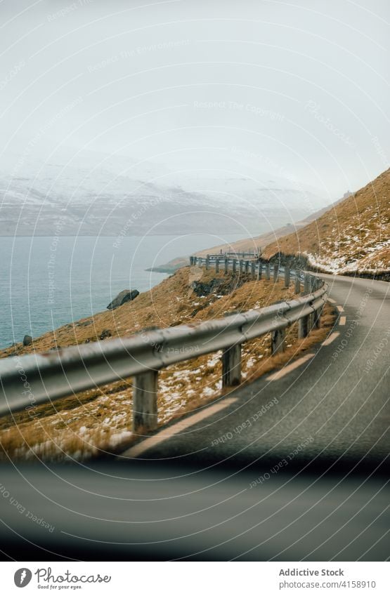 Asphalt roadway in highland area on Faroe Islands mountain river winter snow asphalt direction nature landscape faroe islands scenic water frost range cold