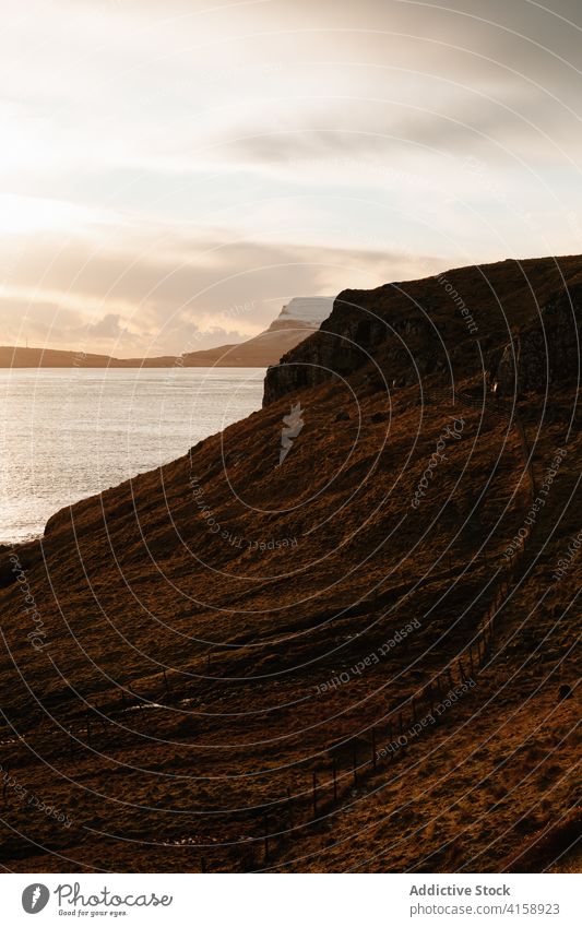 Rocky cliff near sea on Faroe Islands rock seascape winter snow season cold steep terrain faroe islands rocky scenery majestic coast shore water sky calm