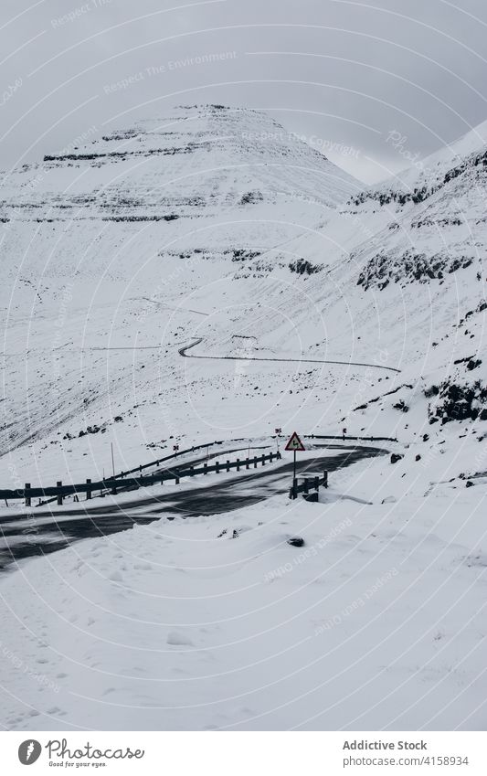 Road in mountains on Faroe Islands asphalt road snow landscape empty nature winter cold roadway cloudy hill scenery trip weather season overcast range ridge