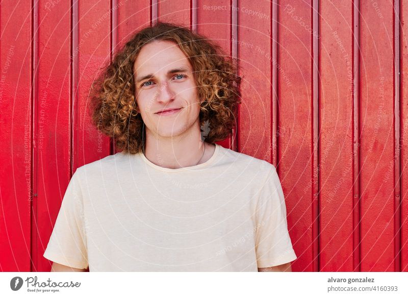 a young man with curly hair and green eyes smiling and looking at camera che attractive person male guy casual white handsome one isolated portrait adult