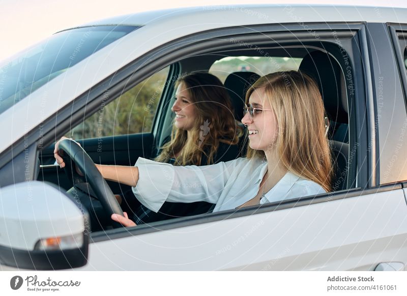 Carefree traveling women in car road trip seaside together friend ride drive summer vacation journey holiday enjoy nature adventure vehicle smile sit cheerful