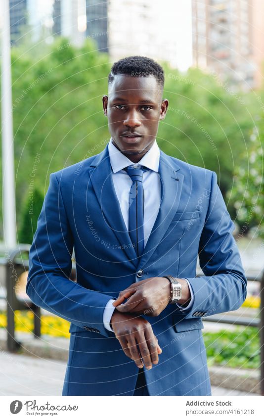 Stylish executive black man in suit walking in downtown with watch businessman confident formal urban respectable modern success elegant manager professional