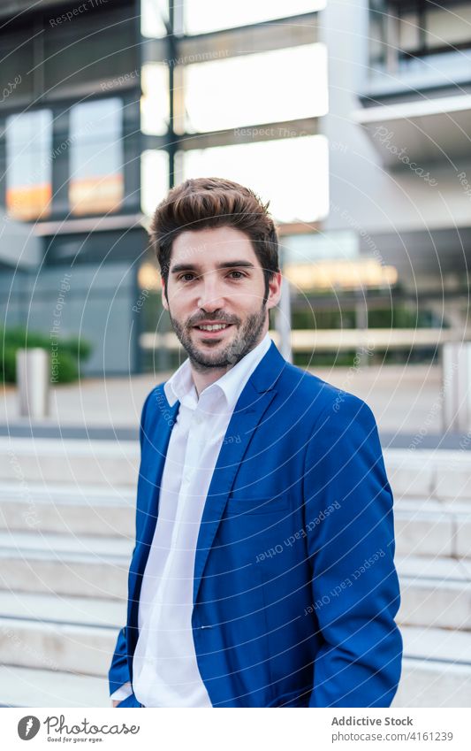 Cheerful executive in formal suit near stairs on street stylish apparel smile haircut modern appearance portrait entrepreneur elegant handsome contemporary man