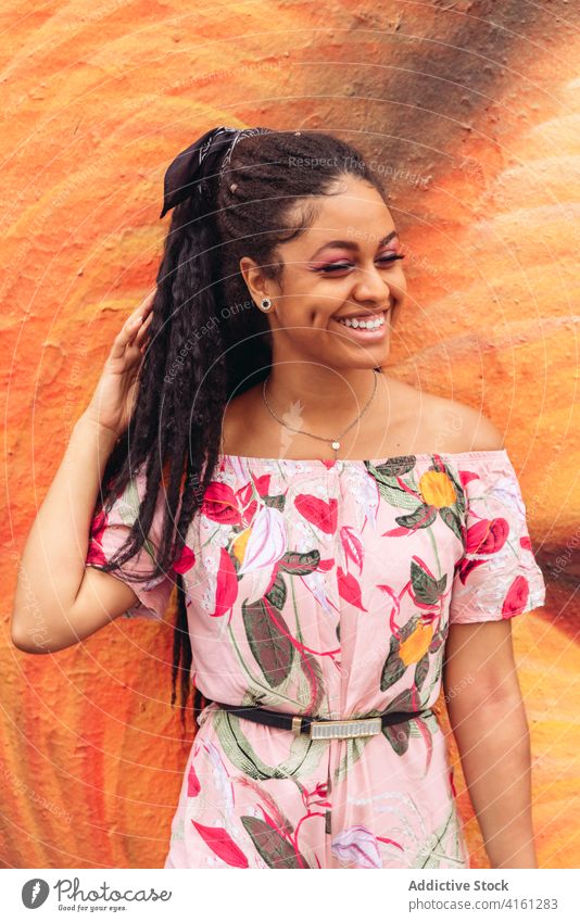 Cheerful ethnic woman in trendy wear on street pavement stylish outfit smile friendly black african american ornament enjoy candid portrait apparel cheerful