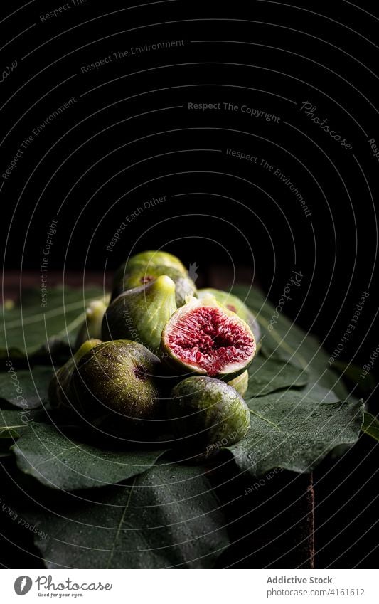 Ripe figs on green leaves on table fruit tropical fresh vitamin healthy food sweet leaf arrangement organic tasty nutrition gourmet vegetarian ripe composition