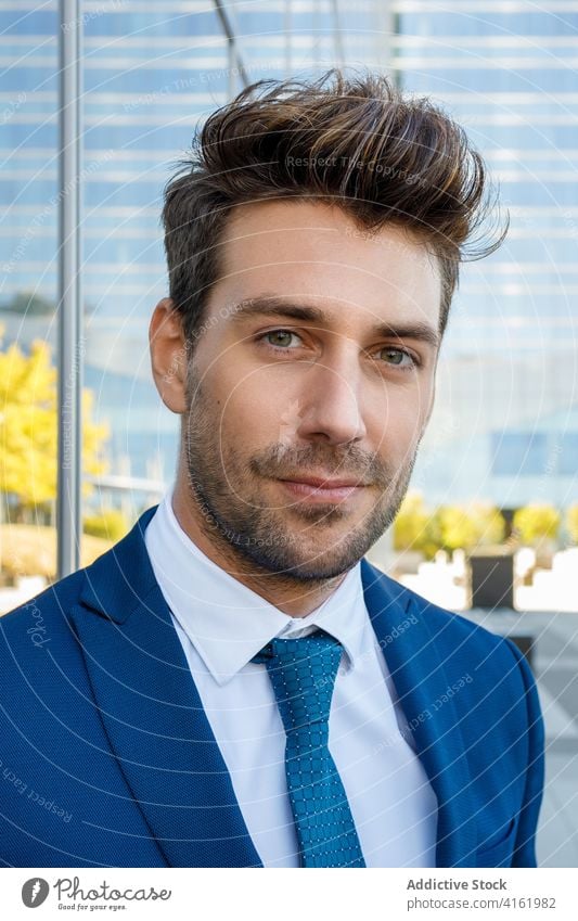 Positive young man in suit standing on street during break positive smile style elegant portrait entrepreneur formal handsome manager businessman confident male