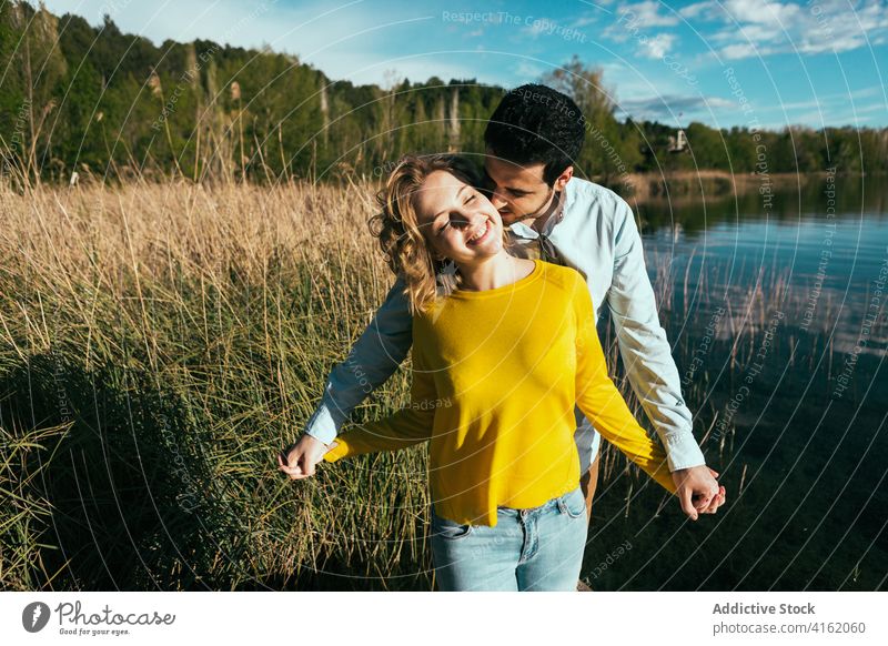 Happy couple embracing gently in nature hug love tender embrace field sunny summer relationship eyes closed girlfriend calm boyfriend together affection happy