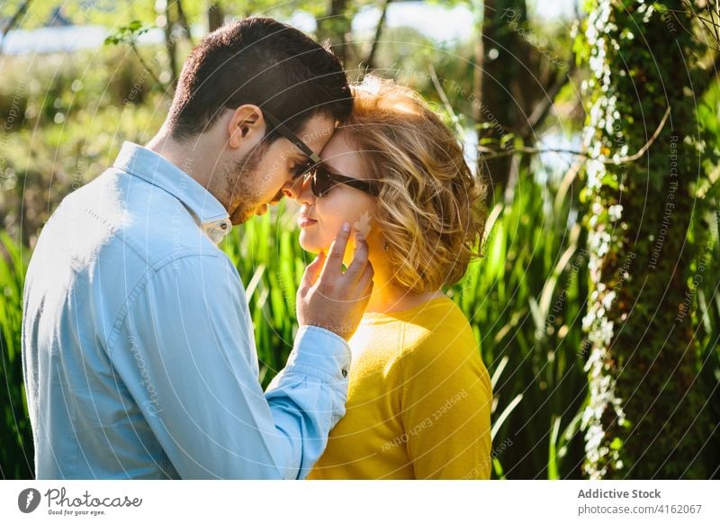 Couple in love in green park couple face to face touch tender relationship summer nature delicate touch cheek calm together affection romantic date girlfriend