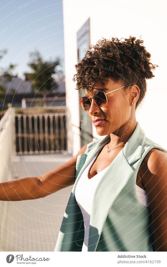 Stylish ethnic woman in sunglasses standing near fence style trendy happy summer afro smile cheerful young female african american black positive relax casual