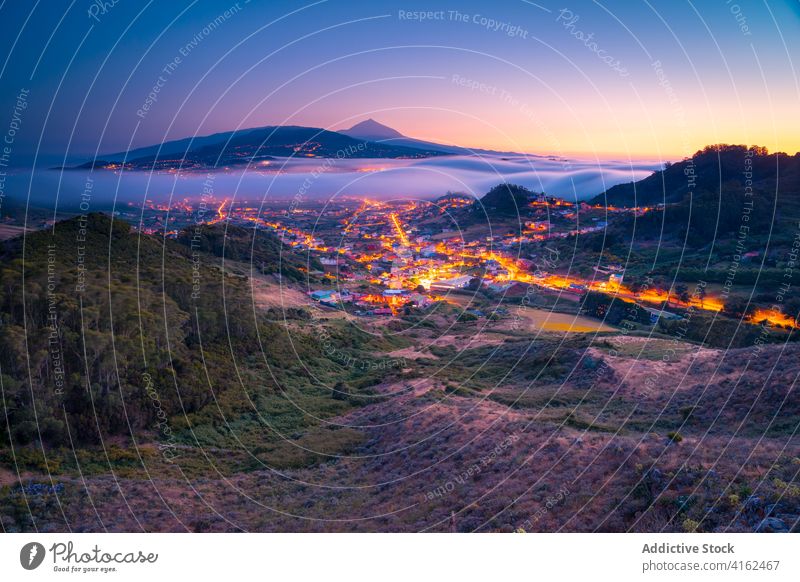 Amazing view of settlement in mountains in morning spectacular city fog highland valley mist thick sunrise canary islands spain tenerife cloud picturesque