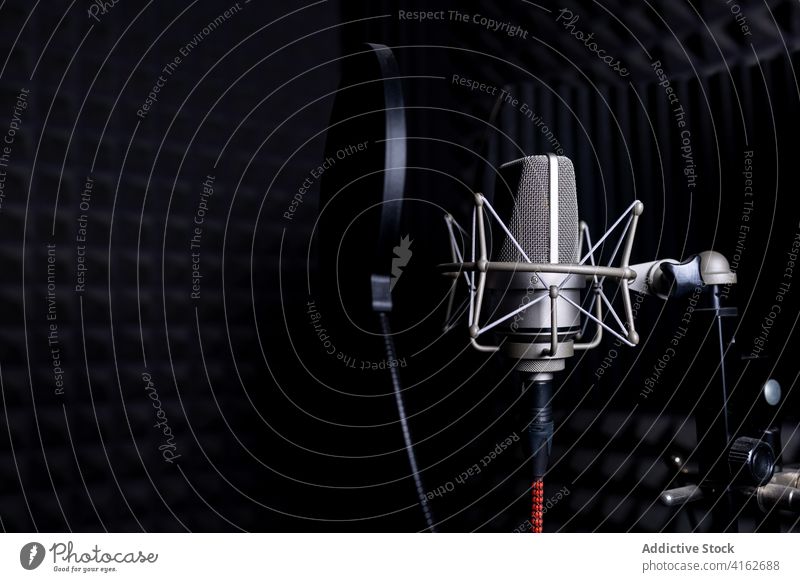 Modern microphone in dark studio record music soundproof foam equipment modern audio professional gadget song melody electronic device metal wire broadcast