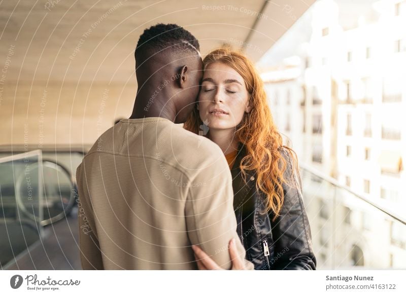 Loving Multiethnic Couple Hugging eyes closed portrait front view hugging standing relationship multi-racial black man caucasian multi-cultural multi-ethnic