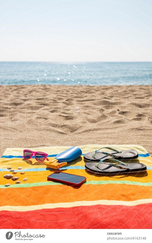 Towel, sunscreen, flip-flops, sunglasses and smart phone on the beach. Summer concept. accessories accessory blue bottle colorful cream fashion holiday journey