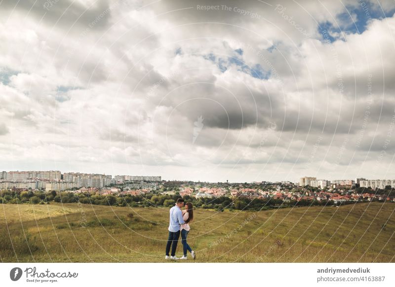 young Couple is having fun on their summer holiday. stylish man and woman are jumping, running and enjoy summer day out of city couple boyfriend grass field