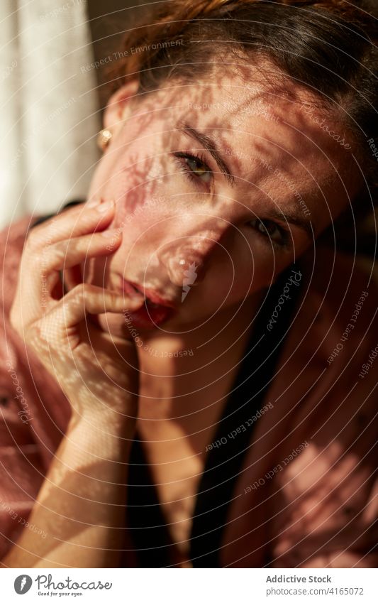 Pensive young woman relaxing near window at home rest dreamy pensive hand on cheek style feminine appearance sunlight female outfit tranquil trendy calm elegant