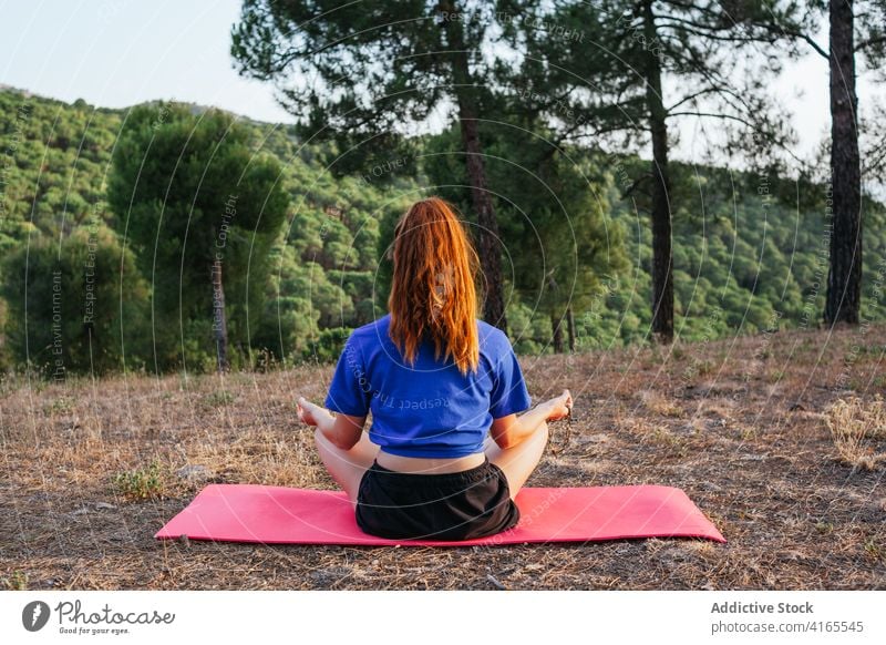 Calm woman doing yoga in Lotus pose meditate mudra lotus pose asana padmasana bead mat nature female gesture peaceful zen tranquil wellness sunset position