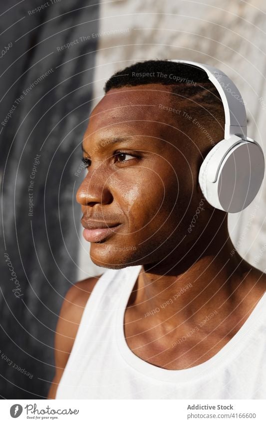 Black serious man listening to music in headphones relax song athlete wireless sound male rest audio melody wellness tune concentrate wellbeing break black guy