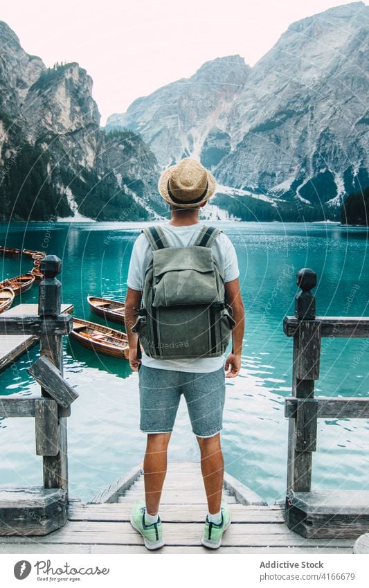 Traveling man on wooden pier near lake turquoise mountain travel adventure wanderlust landscape water male amazing traveler quay scenery vacation trip holiday