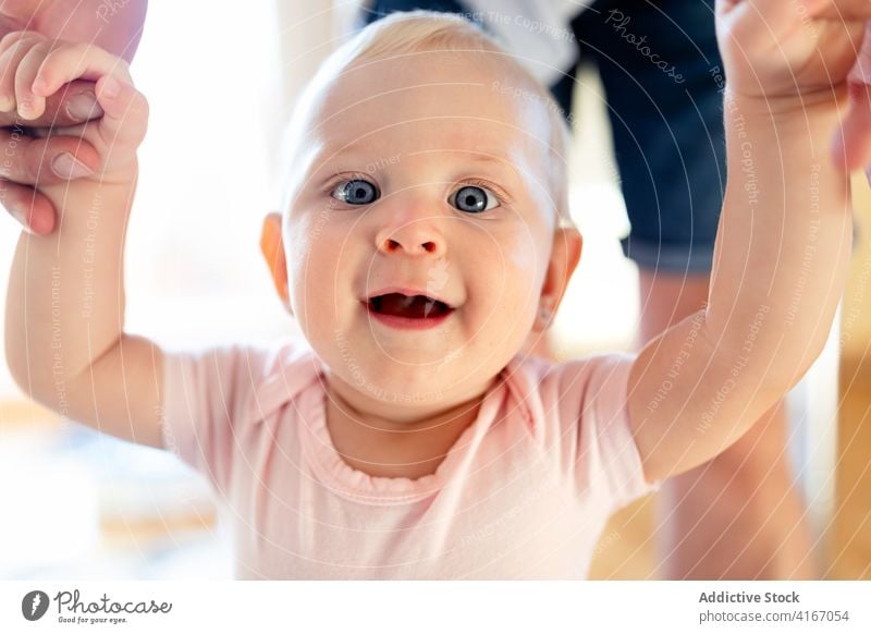 Adorable toddler holding hands of parent at home infant child excited wow kid baby positive cute adorable innocent happy childhood little tender enjoy cheerful