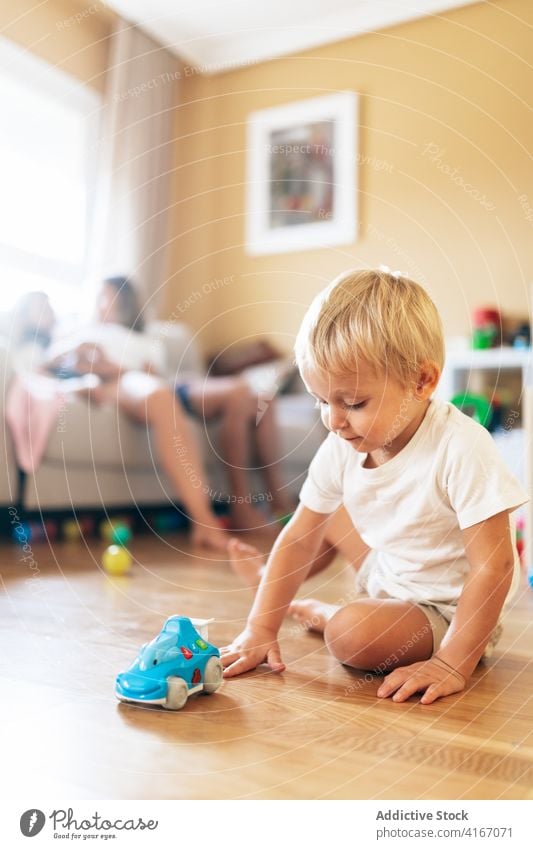 Toddler playing in living room boy toddler baby home pensive family parent childhood game rest innocent blond toy kid at home relax weekend activity apartment