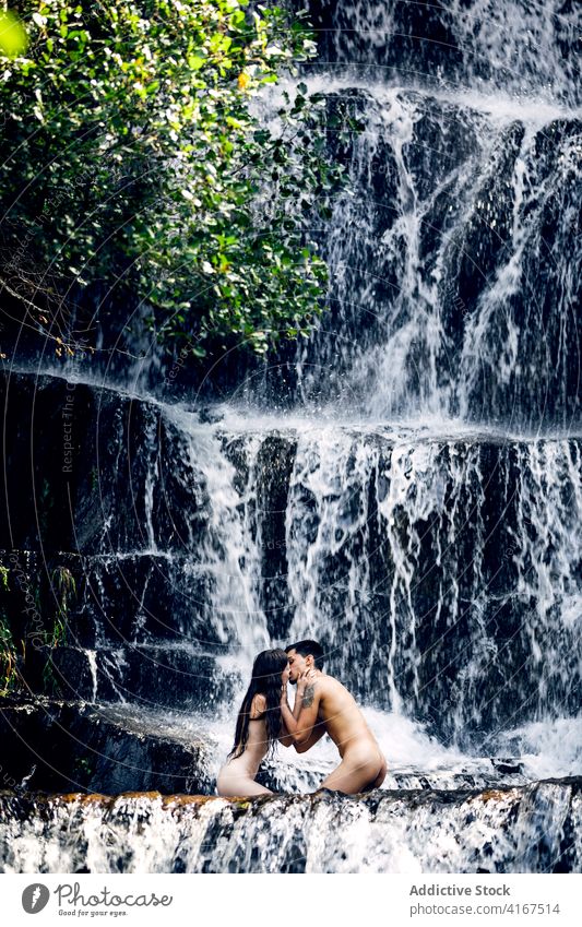 Naked couple hugging near waterfall naked nude vacation together erotic embrace tender summer romantic love relationship intimate nature girlfriend harmony