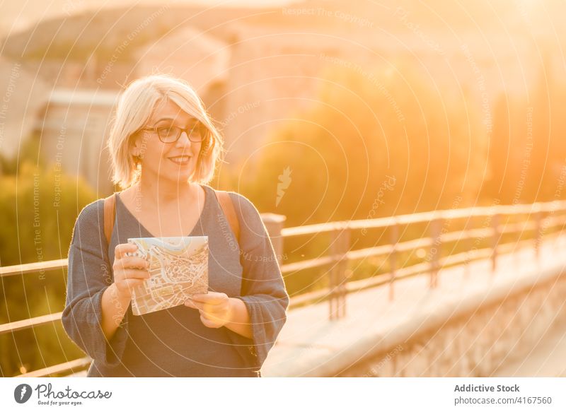 Woman reading touristic map in old town traveler bridge street historic explore woman sunlight route check cuenca spain journey destination location navigate