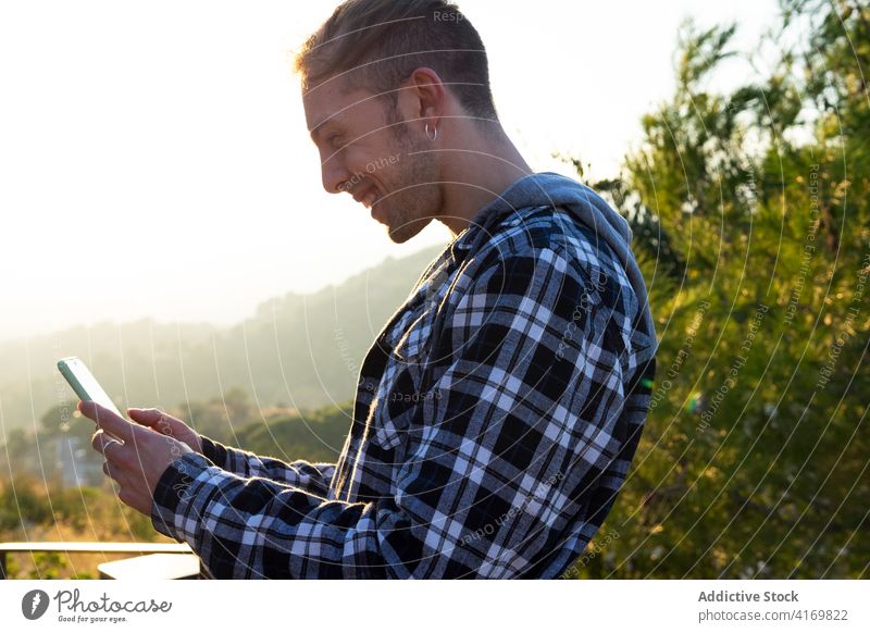 Happy man reading message on smartphone using happy delight hipster gadget young male mobile news device connection browsing lifestyle internet online