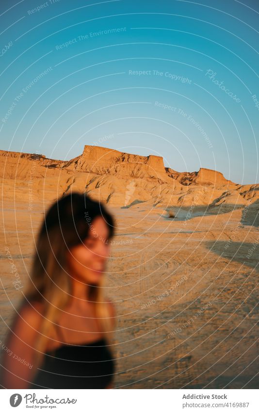 Delighted woman enjoying summer vacation in desert bardenas reales traveler sunset tourism valley dry female spain sunlight nature happy young carefree smile