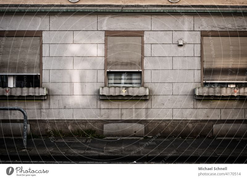 Facade and windows of an old grey apartment building Gloomy dreariness Old Gray roller shutter Window Building Architecture Apartment Building Exterior shot