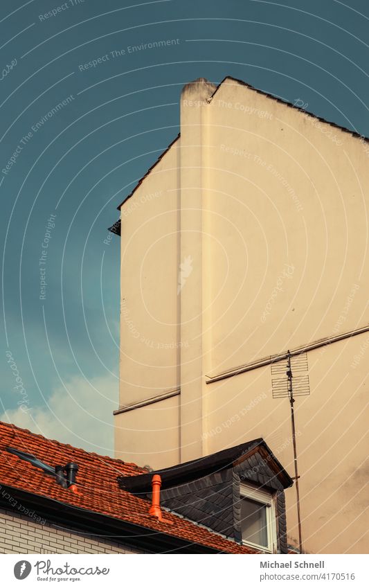 House roof with high antenna in front of lateral house facade without windows Architecture Facade Building Sky Deserted small and big small against large